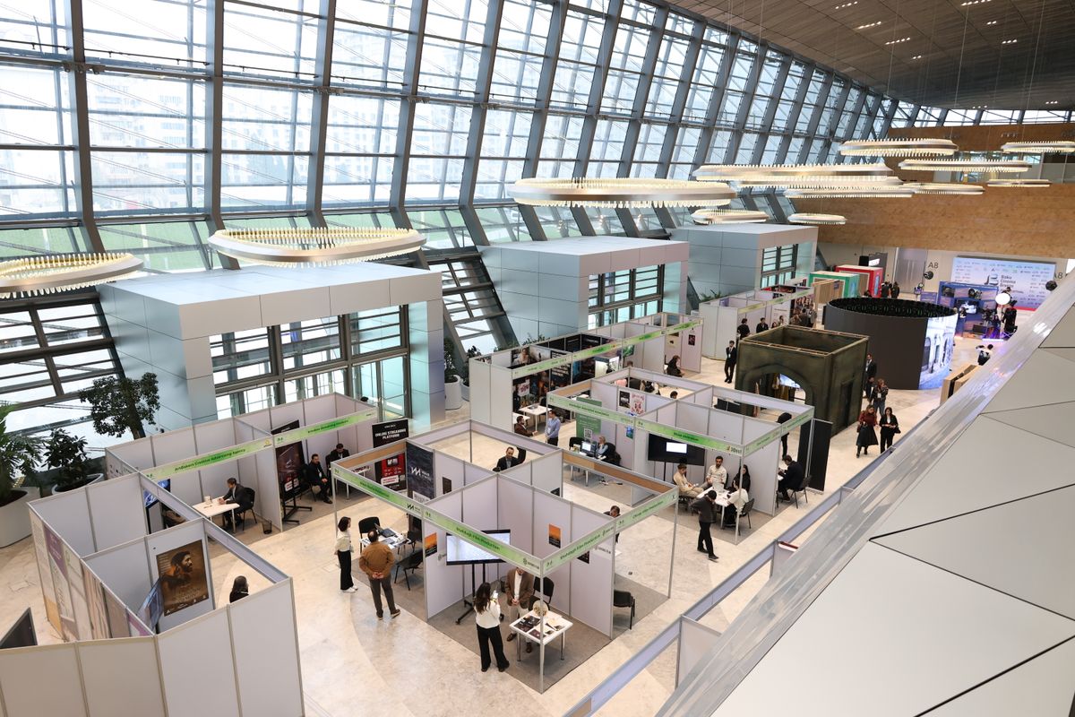 Busy trade show exhibition floor with attendees exploring booths